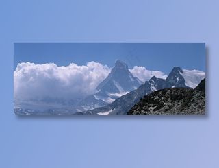 蓝天下白云前的雪峰