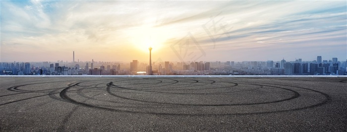 公路上的车轮印记和远处的城市风景高清图片