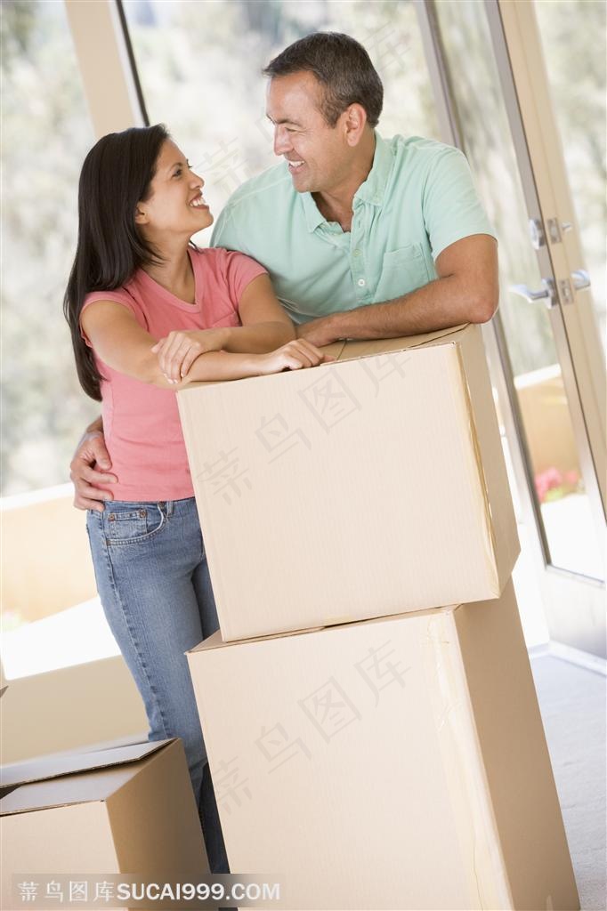 搬家人物-趴在纸箱上对视微笑的外国夫妻
