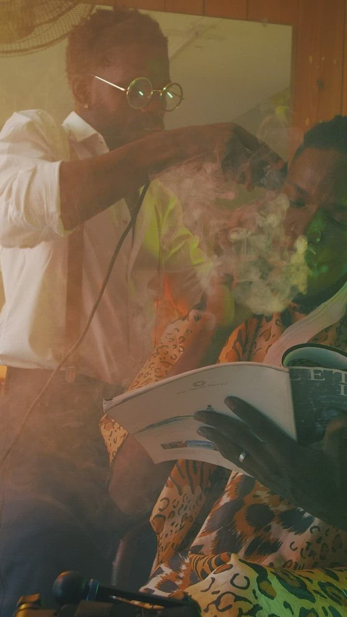 在理发店抽烟和看杂志的男人