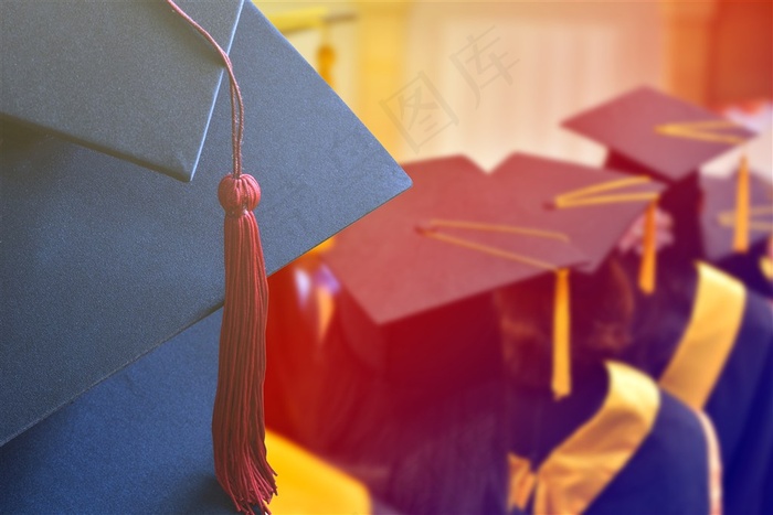 博士帽上的红色流苏和戴着博士帽的学生高清图片