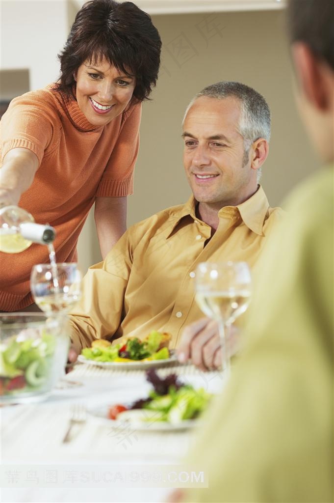 家庭聚会中妻子给丈夫倒酒动作特写