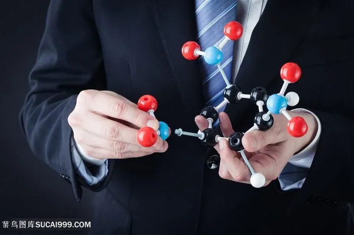 手拿化学结构模型的西装工作人员高清摄影图