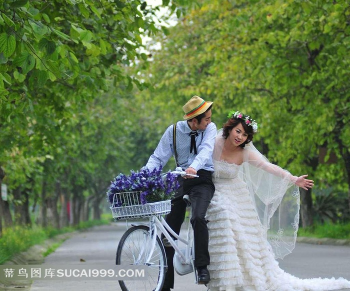 树林中骑自行车的婚纱情侣写真