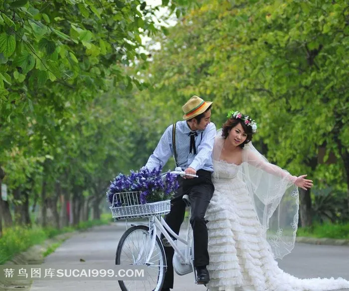 树林中骑自行车的婚纱情侣写真