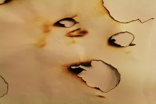 被烧成空洞的纸张图片