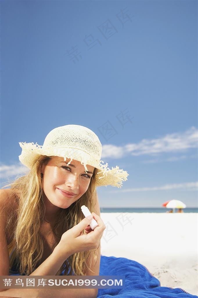 沙滩上戴帽子的金发美女