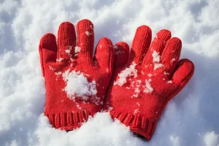 冬天雪地里的红色毛线手套摄影图