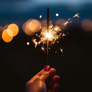 夜晚手拿着点燃的烟花仙女棒闪光摄影图