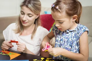 亲子互动母亲陪伴女儿做剪纸做不同的贴纸图案