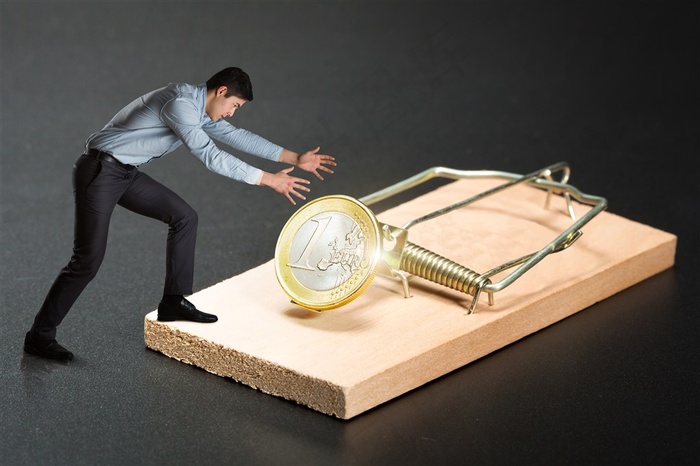 被捕鼠器上的金币诱惑的商务人士高清图片