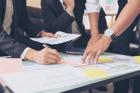 拿着图纸讨论的商务人士高清图片