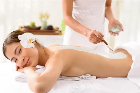 美女背部涂抹护肤泥的按摩师