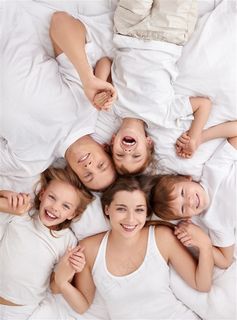 一家人躺在床上的高清摄影图片