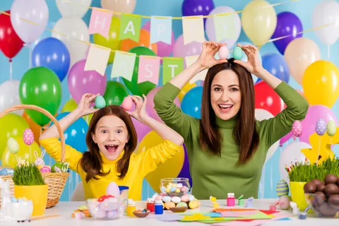 有吸引力的有创意高兴的女孩举在头上的鸡蛋像兔子耳朵有趣的明亮生动的背景