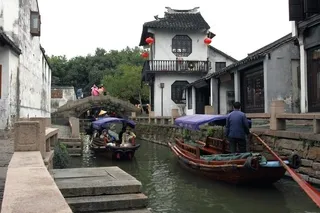 水面上行驶的货船及两边的建筑民宅