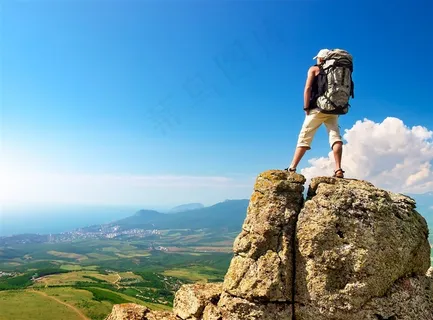 登山站在石头上俯视平原的男子高清图片