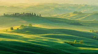 春日阳光下绿色连绵山脉草坪