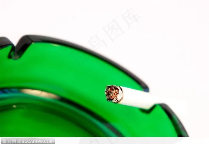 香烟谜烧-绿色玻璃烟灰缸上的香烟
