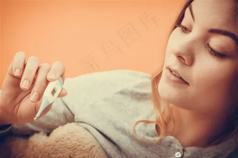 手拿体温计感冒生病的美女