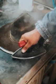 手拿电熨斗熨帽子图片