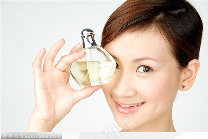 手拿香水在眼睛前的女性