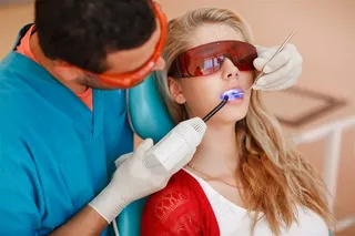 为戴眼罩的女患者补牙的男医生