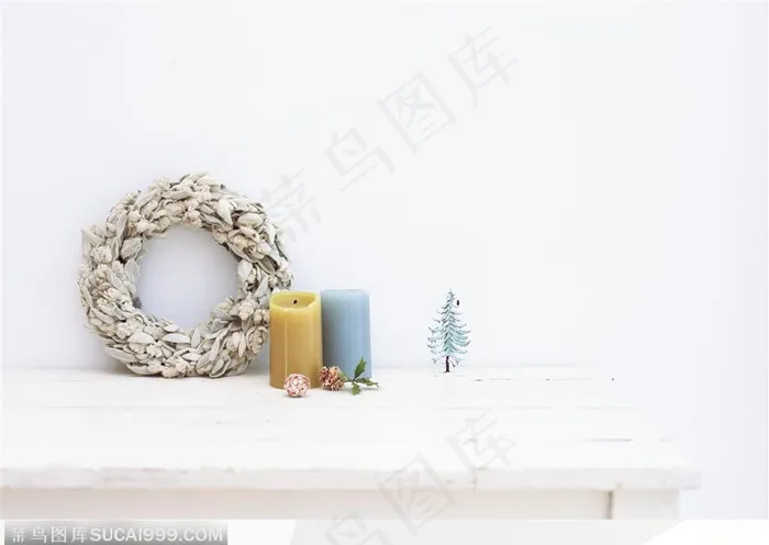放在桌子上的白色花环与彩色大蜡烛