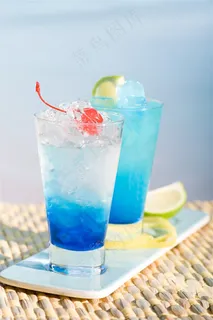 阳光海边竹垫上的蓝色冰镇水果柠檬鸡尾酒果汁 阳光海边竹垫上的蓝色冰镇水果柠檬鸡尾酒果汁