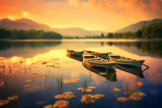 清澈的湖泊上停着整齐的几艘船摄影图