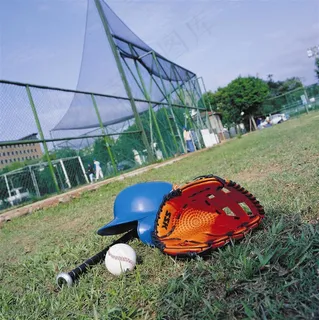 体育运动-棒球场草地上放着的棒球手套和棒球帽子