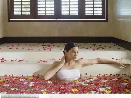 泡在铺满花瓣的浴缸里的女子