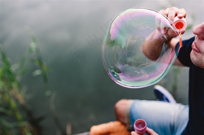透明的泡泡被男子吹出来图片