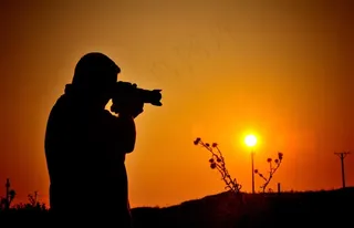 正在拍夕阳的职业人物剪影拿相机摄影师图片