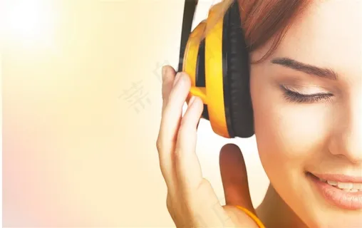 戴着黄色耳麦听音乐的美女高清图片