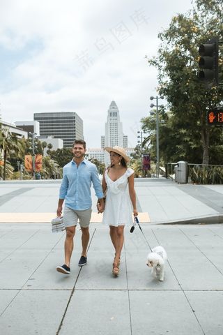 一对情侣牵着手遛狗图片
