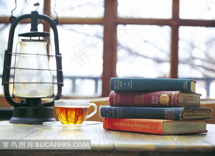 桌子上的外文书籍和油灯茶杯