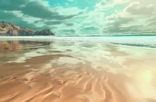 波涛汹涌的海岸倒映在沙滩上，浅青色和浅米色的风格，充满活力的舞台背景，宾得645n，迷人摄影图