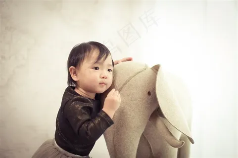 靠在玩具大象上的可爱幼儿 靠在玩具大象上的可爱幼儿