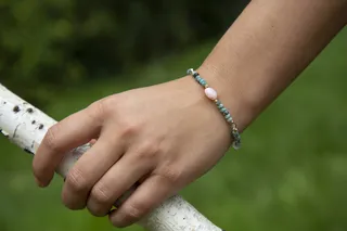 抓着树枝的手上戴着漂亮的手链特写