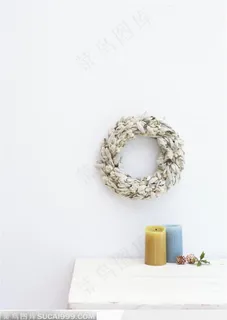 挂在墙壁上的花环与桌子上的彩色蜡烛