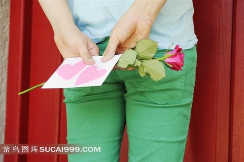 背对着手拿情人节玫瑰和情书的人