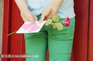 背对着手拿情人节玫瑰和情书的人