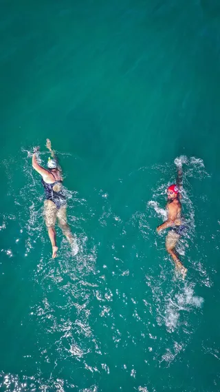 两人在水面上游泳的照片