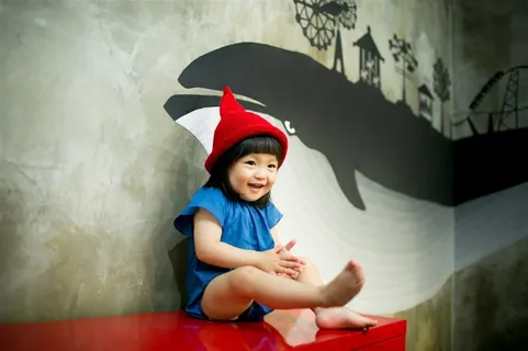 坐在桌子上笑的可爱小女孩