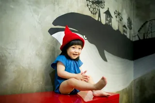 坐在桌子上笑的可爱小女孩