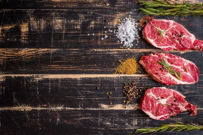 黑色木板上的三块生牛肉