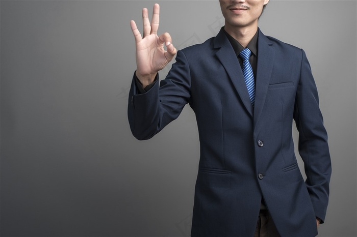 单手比出ok手势的西服男子