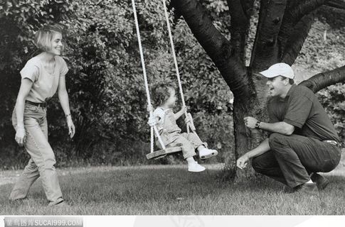 黑白秋千上的儿童与陪伴的大人