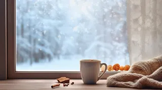 冬日窗外的雪景和窗台的咖啡摄影图